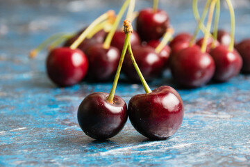 Delicious sweet cherry macro on blue textured background with copy space, berries close up