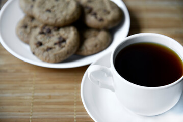Tea pair and oatmeal cookies with chocolate on a mat. Delicious breakfast with tea and sweet cookies.