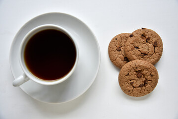 Tea pair and oatmeal cookies with chocolate on a white background. Delicious lunch with tea and sweet cookies. Porcelain tea set with a hot drink.