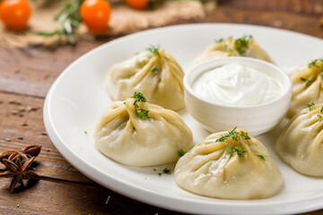 Manty with beef and sour cream on wooden table