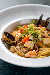Pasta spaghetti with seafood on a white plate, mussels, shrimps, octopus,squid