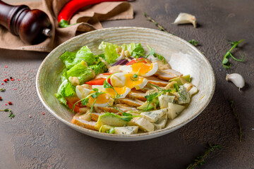 Cobb salad with chicken, egg and blue cheese on a plate on brown table