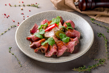 Sliced roast beef on plate on brown table