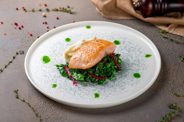 Salmon steak on the grill spinach and mashed selery on plate