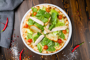 Pizza Caesar on plate on wooden table