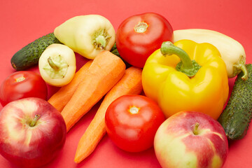 Close up view from the top of many different vegetables and fruits isolated on red background.