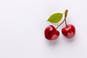 Cherry berries on a pastel background top view.  Background with a cherry on a sprig, flat lay