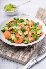 Salmon salad with avocado,  for keto and low carb diet. Rusty background, top view, copy space.
