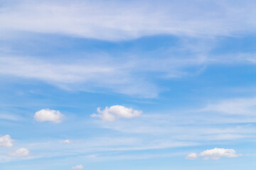 Sunny weather with cumulus and cirrus clouds on blue sky.