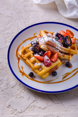 Soft wiley with strawberries, blueberries, blackberries, powdered sugar and caramel
