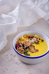 Cream soup with champignons, parmesan, fried onions and flower petals