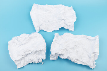 A piece of crumpled white paper on a blue background.