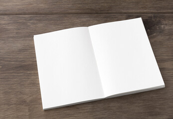 Blank white spread notebook on the desk from an oblique angle	
