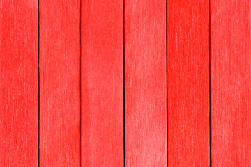 Textured wood background from red boards. The wooden planks are painted red and arranged vertically. Colorful red bright detailed background.