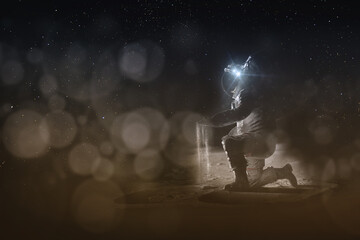 An astronaut on the moon sits on one knee above the craters and holds the soil in his hand. Space exploration concept. Dark template for light text. Elements of this image furnished by NASA.