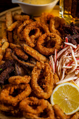 Onion rings in batter, rye croutons, French fries, lemon and squid shavings