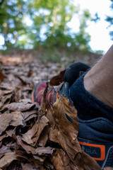 man's foot climbing a mountain hill full of leaves. Relaxing in nature