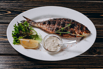 There is a oval plate with the fried fish on it.