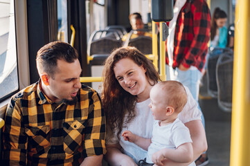 Parents riding a bus with their child during a day.