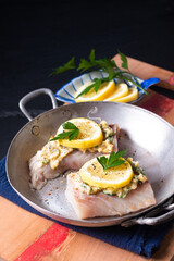 Healthy Food concept preparation for Homemade Lemon garlic butter Baked Cod fish on black background with copy space