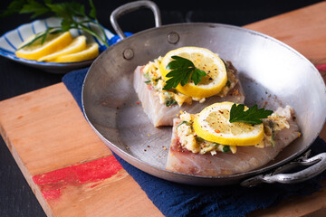 Healthy Food concept preparation for Homemade Lemon garlic butter Baked Cod fish on black background with copy space