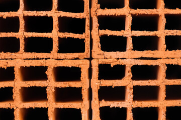 Una pila de ladrillos hechos de arcilla roja. Vista de frente y de cerca. Concepto: Material de construcción ecológico, ladrillo hueco de arcilla.