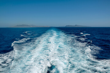 Panoramic view of Santorini island and wave trails of a floating ferry boat