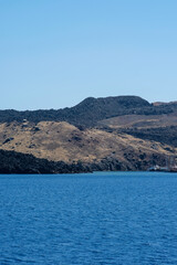 Fototapeta premium Close up view of the island of volcanic origin, Nea Kameni, that has been formed over repeated eruptions of dacite lava and ash in Santorini