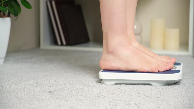 A woman comes over and stands on the scales. Weight Control and Weight Loss.
