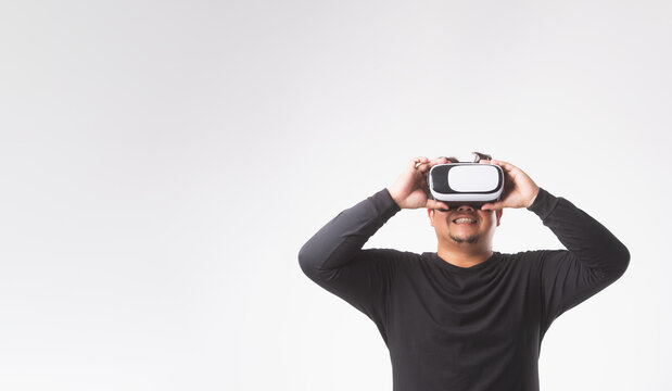 Asian man touching air, wearing VR headset, glasses or gadget. Man plays VR game ,Futer technology of modern concept.