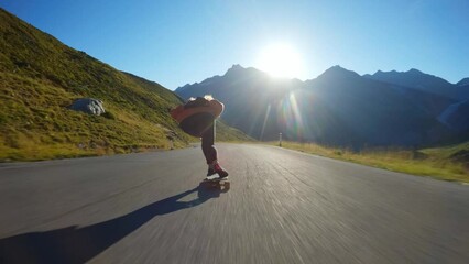 Cinematic downhill longboard session. Young woman skateboarding and making tricks between the curves on a mountain pass. Concept about extreme sports and people
