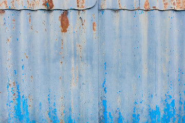 Corrugated metal in blue paint texture old fence background weathered obsolete