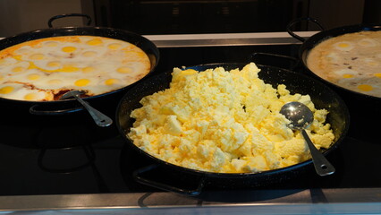 Fried and scrambled eggs and omelette in a self-service buffet with hot breakfast in the hotel. Continental breakfast concept.