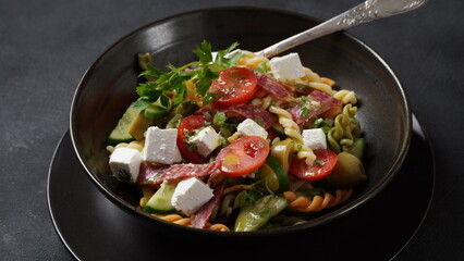 Italian pasta salad cucumbers, cherry tomatoes, olives, red onion,  salami, feta cheese, and Rotini