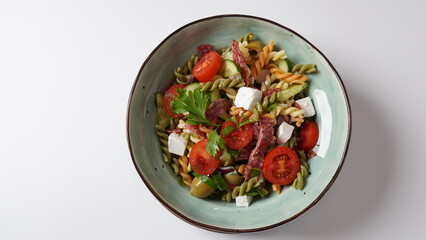 Italian pasta salad cucumbers, cherry tomatoes, olives, red onion,  salami, feta cheese, and Rotini