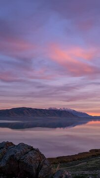 Timelapse of colorful sunset over Utah Lake from the Knolls as colors change reflecting in the water.