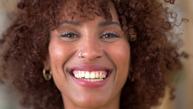 Face portrait of an Afro woman or beauty stylist looking confident and empowered in her natural hair. One happy and funky African female with a cool retro hairstyle and a big cheerful smile