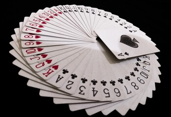 playing cards on black background with a circular orientation