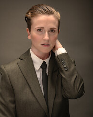 Young, attractive, gender non-binary, Los Angeles citizen poses in studio wearing a suit and tie. 