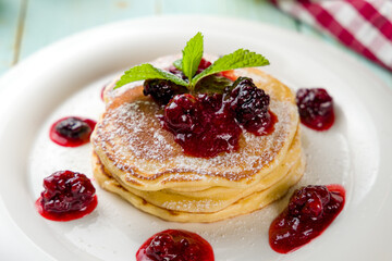 pancake with berries sauce and on white plate macro close up