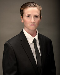 Young, attractive, gender non-binary, Los Angeles citizen poses in studio wearing a suit and tie. 
