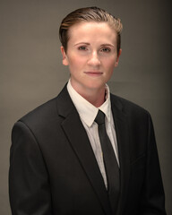 Young, attractive, gender non-binary, Los Angeles citizen poses in studio wearing a suit and tie. 