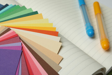 Color palette and pens on notebook, closeup