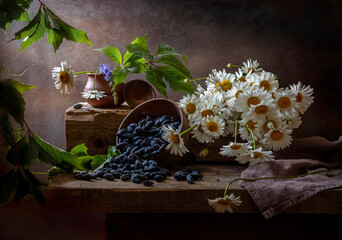 Still life with honeysuckle in a bowl and a bouquet of daisies on an old wooden table © 02irina