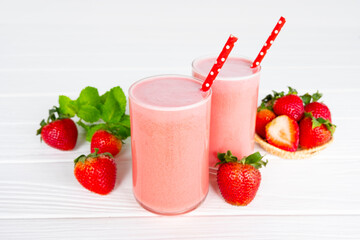 Strawberry yogurt fruit juice smoothie pink colorful fruit juice milkshake blend beverage healthy high protein the taste yummy In glass drink episode morning on white wood background.