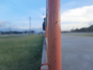 A young boy sitting on a iron fence at a inline scater track