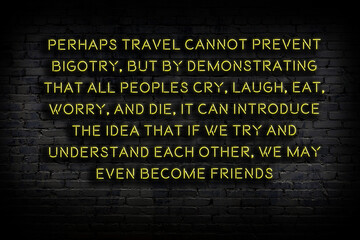 Night view of neon sign on brick wall. Wise qoutation.