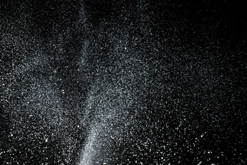 Fototapeta na wymiar Texture of scattered flour in the air, dark background.