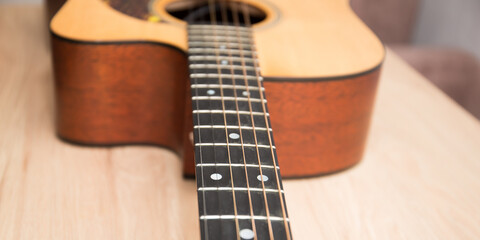 Obraz premium A fragment of the body of an acoustic six-string guitar.