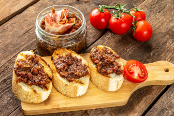 Baguette with bacon jam on a wooden table.